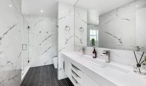 Explore the elegance of a modern bathroom featuring marble walls and sleek fixtures.